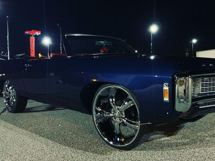 The black Impala convertible on large chrome wheels, photographed at night