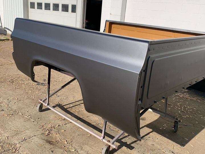 Pickup bed painted satin charcoal, on a stand outside the shop